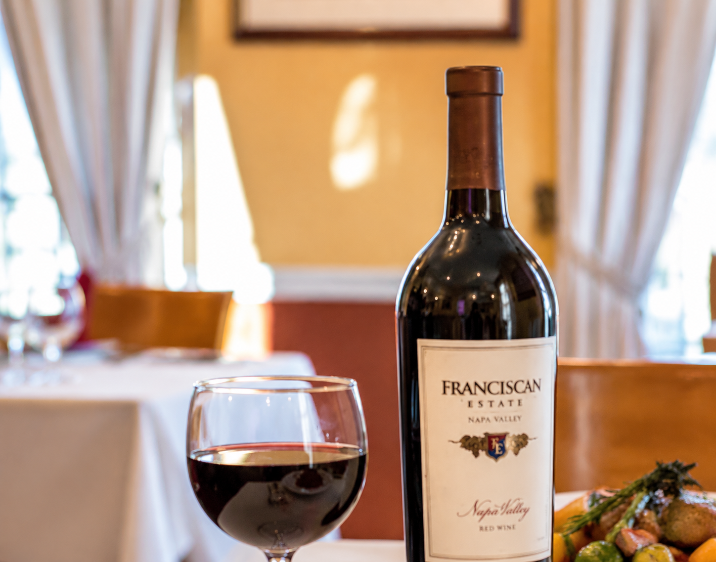 Red wine and bottle on a warmly lit table